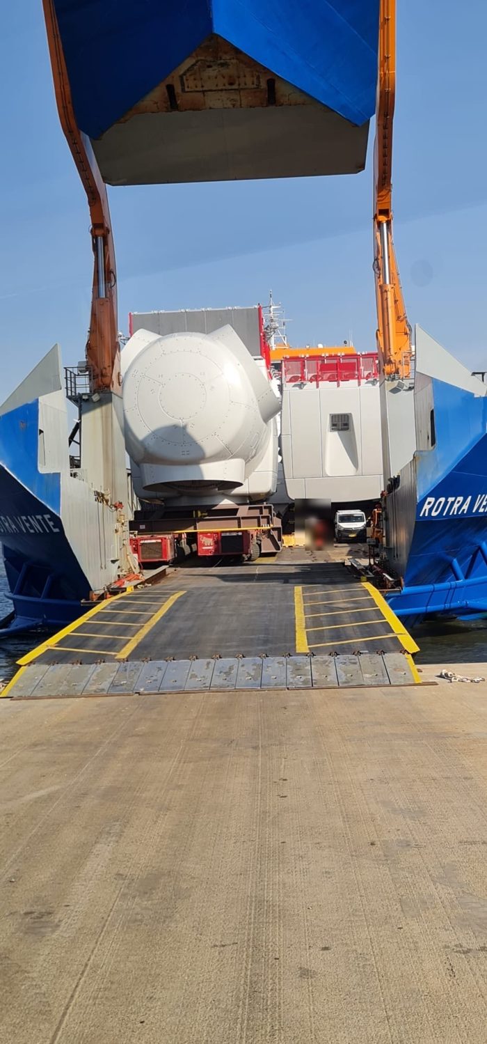 Offshore wind turbine nacelle being rolled onto a ro/ro transport vessel