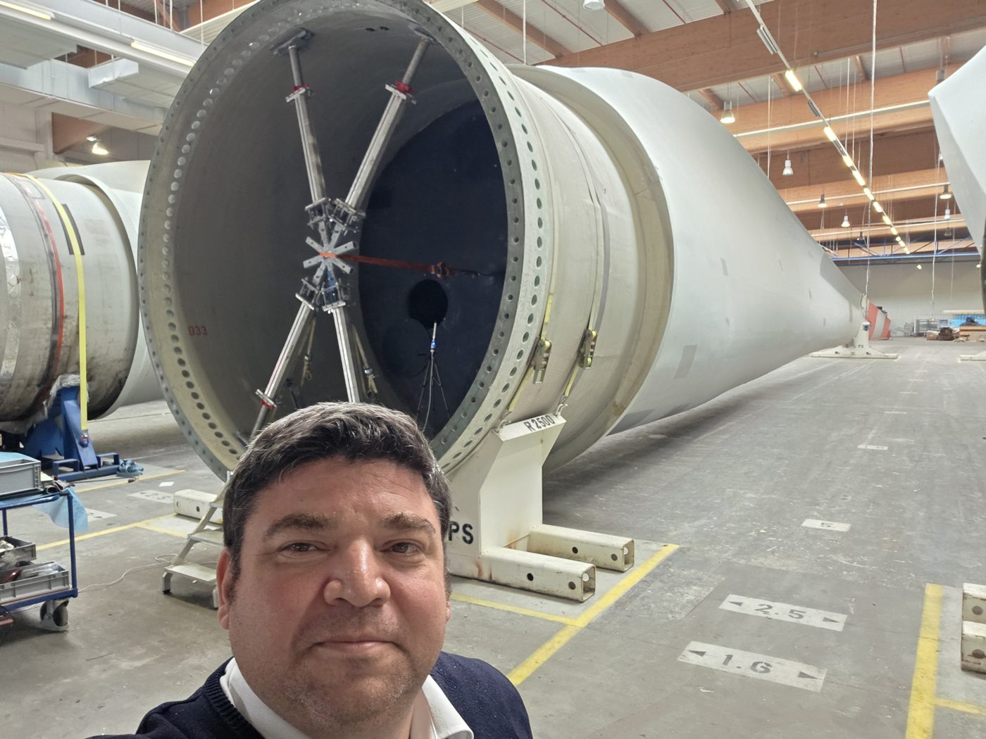Full-scale rotor blade root in a manufacturing hall, seen up close during a site visit